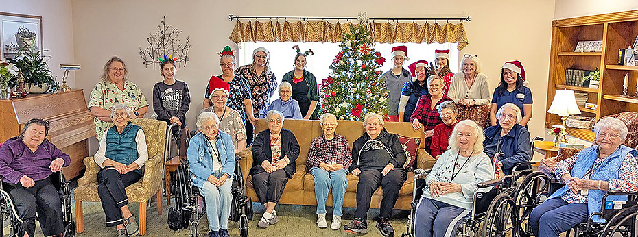 The CrestRidge family of residents and staff posed by the Christmas tree